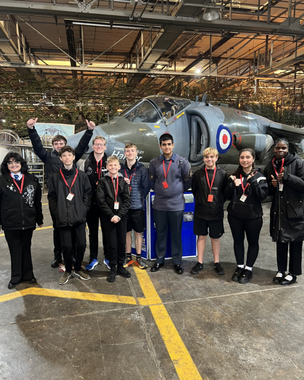 Students stood in a group in front of a fighter jet aeroplane