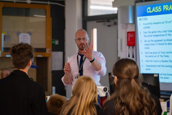 Photo of a teacher stood in front of students