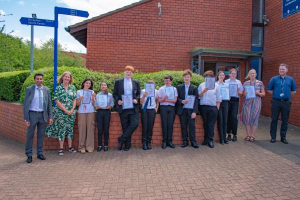 Photo of the staff and students stood outside our conference centre holding their certificates