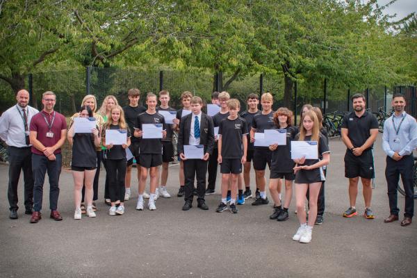 Photo of staff and students stood outside holding certificates