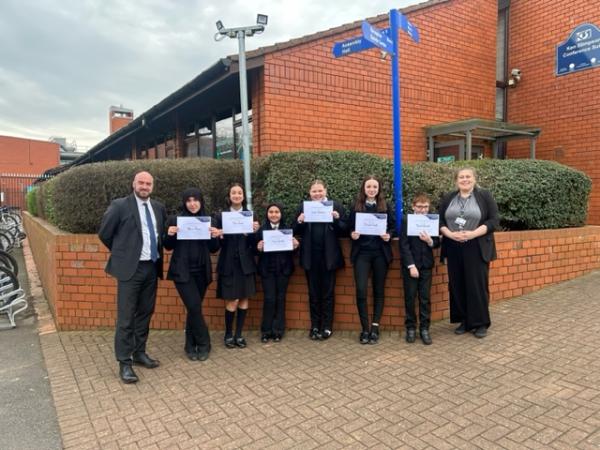 Students stood outside the conference centre holding their certificates with the Headteacher and Deputy Head of Year